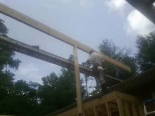 Carpenter setting a ridge beam over a new addition frame — Ice Dam Removal by Roofing Brothers in Kewanee