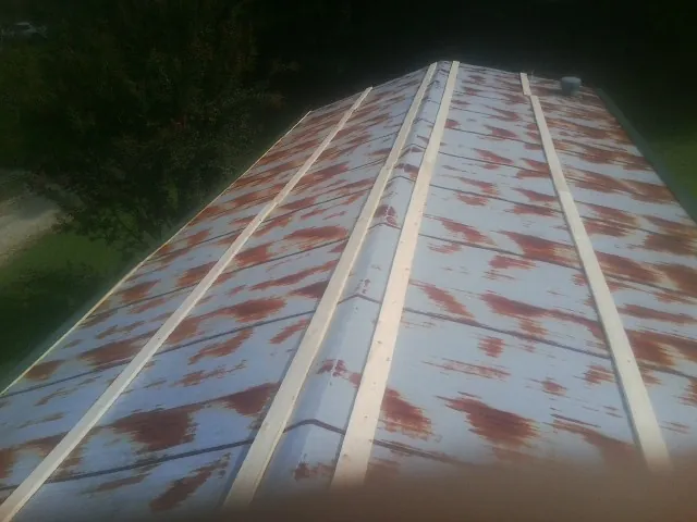 Rusted metal roof panels with new wood purlins before replacement — Storm Damage Roof Repair in Kewanee by Roofing Brothers