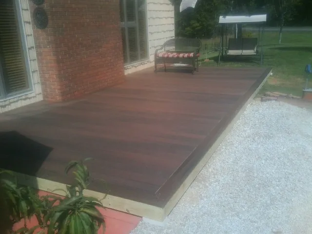 Freshly stained wood deck built against a brick home in Kewanee