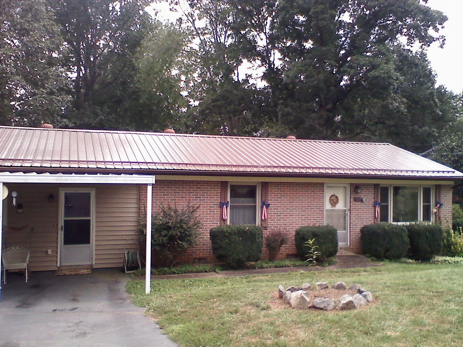 Bronze metal roof and carport on a brick ranch home — Roof Repair work by our crew in Kewanee